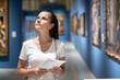 © JackF - Young woman with guide brochure looking at artworks in museum