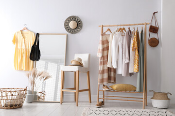 Wall Mural - Rack with stylish women's clothes and mirror indoors. Interior design