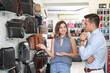 © Pixel-Shot - Female seller working with man in modern bag shop