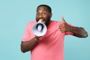 excited young african american man guy in casual pink t-shirt isolated on blue wall background studi