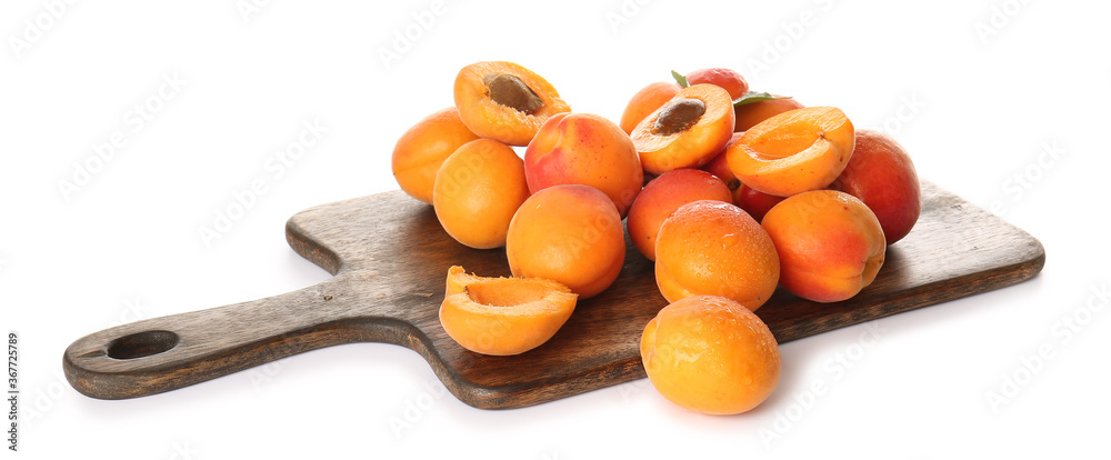 Board with tasty ripe apricots on white background