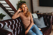 © InsideCreativeHouse - Happy adult woman relaxing on her couch at home in living room