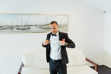 Wall Mural - Portraits of the groom at the hotel training camp, dressed as a businessman in a black suit, tuxedo and white shirt