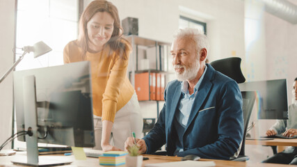 Poster - Handsome Middle Aged Creative Engineer Sitting at the Desk working on Desktop Computer Has Discussion with Beautiful Female Project Manager. Office with Friendly Colleagues Chatting, Finding Solutions