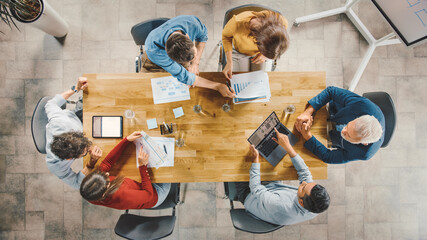 Aufkleber - In the Startup Meeting Room Team of Entrepreneurs sitting at the Conference Table Have Discussions, Solve Problems, Use Digital Tablet, Laptop, Share Documents with Statistics and Charts. Top View