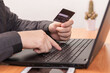© Cherdchai - Close-up Of A Man's Hand Holding Blank Credit Card During Using Laptop. Business concept and Online concept