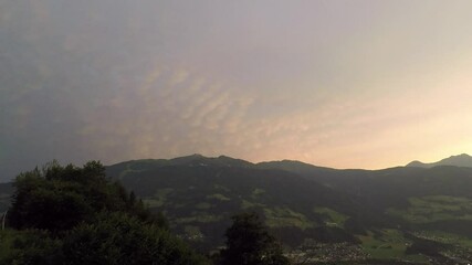 Wall Mural - Time lapse of mammatus clouds from a severe thunderstorm over the Alps at sunset