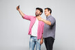 © F8  \ Suport Ukraine - Portrait of a two excited young men taking a selfie while standing together isolated over white background