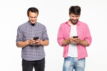 Portrait of a two young men holding mobile phones and looking at each other isolated over white background