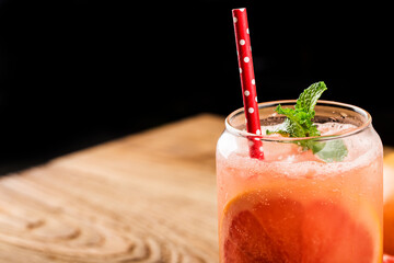 Wall Mural - A glass of ripe grapefruit with juice on wooden table close-up