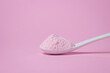 © Ruzanna - A spoon with pink powder on a pink background. Gelatinous dessert mix of pink color, with cherry flavor.