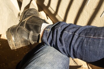 Wall Mural - Top view of male legs in jeans and old leather shoes