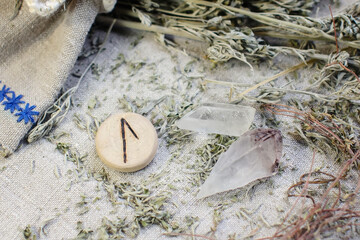 Scandinavian wooden rune Laguz, Lagu on a rough linen cloth with amethyst crystalline, rock crystal and dried wormwood