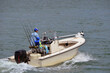 Fisherman in a small one fishing boat powered by a single outboard engine.