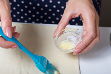A Woman Greases Puff Pastry With Butter. For Making Puff Pastry Curls With Poppy And Walnut Filling.