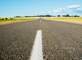 asphalt road to horizon.Summer green fields. blue cloudless sky