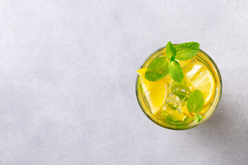 Lemonade, lemon, mint cocktail in glasses. Grey background. Copy space. Top view.