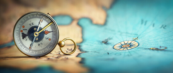 Magnetic old compass on world map.Travel, geography, navigation, tourism and exploration concept background. Macro photo. Very shallow focus.