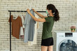 Young woman doing laundry at home.
