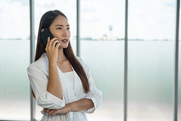 Young Asian woman talking on mobile phone with seriously.