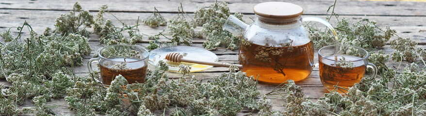 Herbal medicinal background.Healthy tea with yarrow flowers on a wooden rustic table. Place for text.