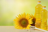 Fototapeta Zwierzęta - Sunflower oil in bottles, seeds and flowers of sunflower close up with copy space for text