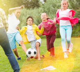 Children are playing football in the park.