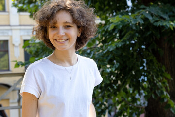 Portrait of a young woman on the background of a city park.