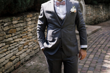 man in suit and bow tie near brick wall