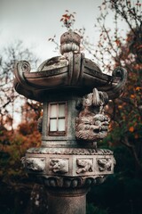 Canvas Print - Vertical shot of a concrete sculpture at traditional styled Japanese Adelaide Himeji Gardens