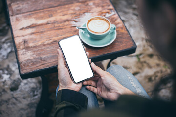 cell phone mockup image blank white screen.woman hand holding texting using mobile on desk at coffee shop.background empty space for advertise.work people contact marketing business,technology