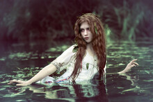 Art Photo Of A Forest Drowned Woman In The Dark Muddy Water Of A Swamp