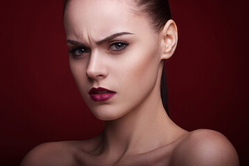 Beautiful studio portrait of young woman with perfect skin with make-up red lips 