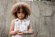 Selective focus of african american kid with messy face holding metal plate and spoon on urban street