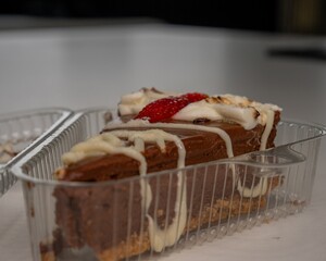 Canvas Print - Closeup of a chocolate cake with cream in a plastic box