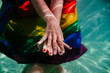 © Eva - two women at the pool together wrapped with rainbow gay flag. LGBT concept