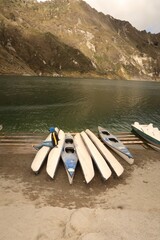 Poster - Shot of a person sitting on the kayak boat near the lake with mountain background  in Ecuador