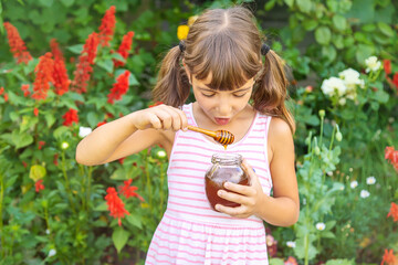 Child eats honey summer photo. Selective focus.