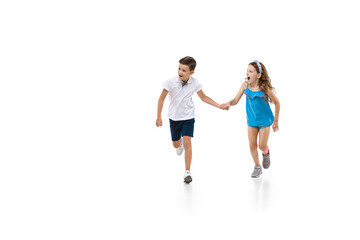 Wall Mural - Happy kids, little and emotional caucasian boy and girl jumping and running isolated on white background. Look happy, cheerful, sincere. Copyspace for ad. Childhood, education, happiness concept.