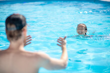 Instructor Backs And Swimming Boy In Pool