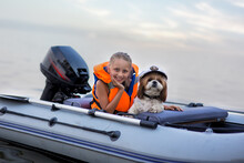 Little Girl In A Life Jacket With Her Dog In A Boat On The Lake. Safety. Summer Rest.