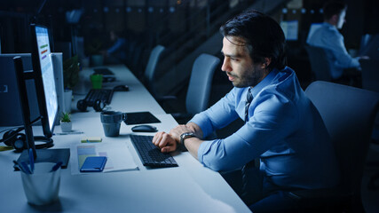 Aufkleber - In the Office at Night Overworked Tired Office Worker Uses Desktop Computer. Tired Exhausted Businessman Almost Falls Asleep at His Job