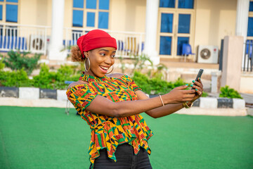 Poster - pretty young african girl holding her phone, feeling excited