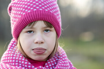 Wall Mural - Pretty child girl in warm knitted winter clothes outdoors.