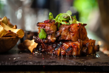 Pork ribs cooked at low temperature. Blackcurrant sauce, parsnip chips with Parmesan cheese. Delicious healthy meat food closeup served on a table for lunch in modern cuisine gourmet restaurant