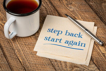 Wall Mural - step back, start again motivational note - handwriting on a napkin with a cup of tea, persistence and determination concept