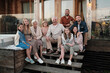 © AnnaStills - Portrait of big happy family sitting on the porch and smiling at camera they gathered in their big house in the country