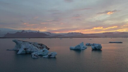 Wall Mural - A high quality 4K footage of the Glacier Lagoon Jokulsarlon in Iceland during the golden hour at colorful sunset lights. Lagoon full of icebergs is one of the most scenic places to visit in Iceland