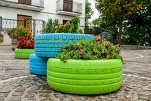 Old Tires That Are Painted In Assorted Colors And Used For A Flower Planter, Modern Garden