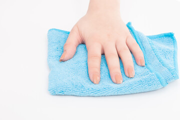 Female hand wipes a white surface with a blue microfiber cloth